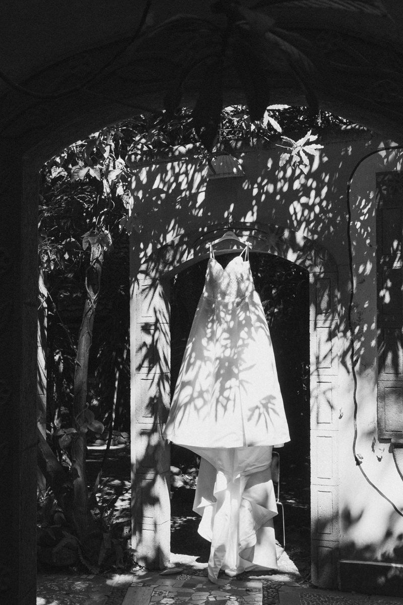 White garments hanging on a clothesline cast dappled shadows in black and white photography.