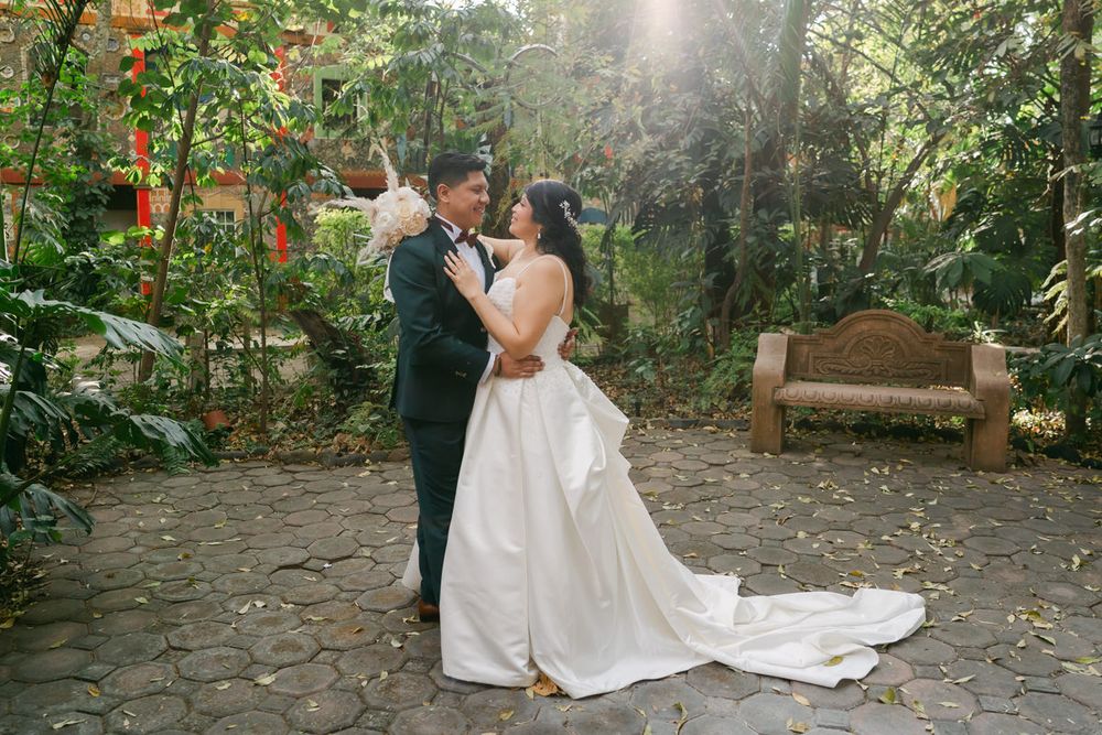 Elegant wedding photography session in a garden setting with stone pathways and natural lighting.