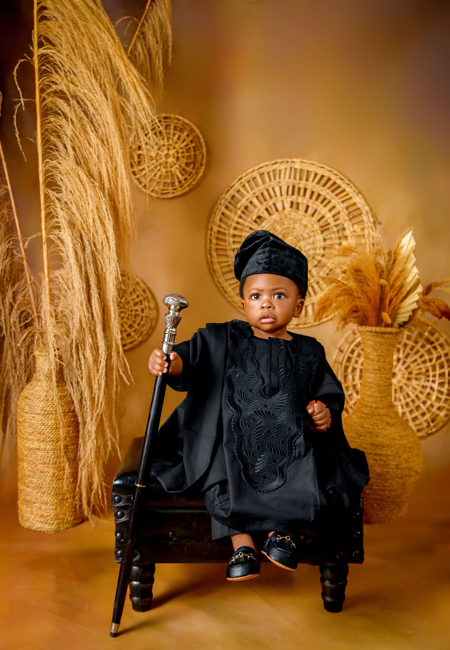 Studio portrait setup with woven rattan decorations and warm golden lighting.