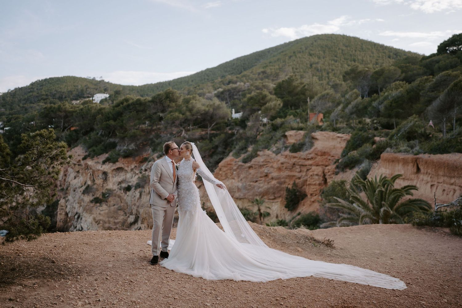 bride and groom kissing on cliffs at amante ibiza