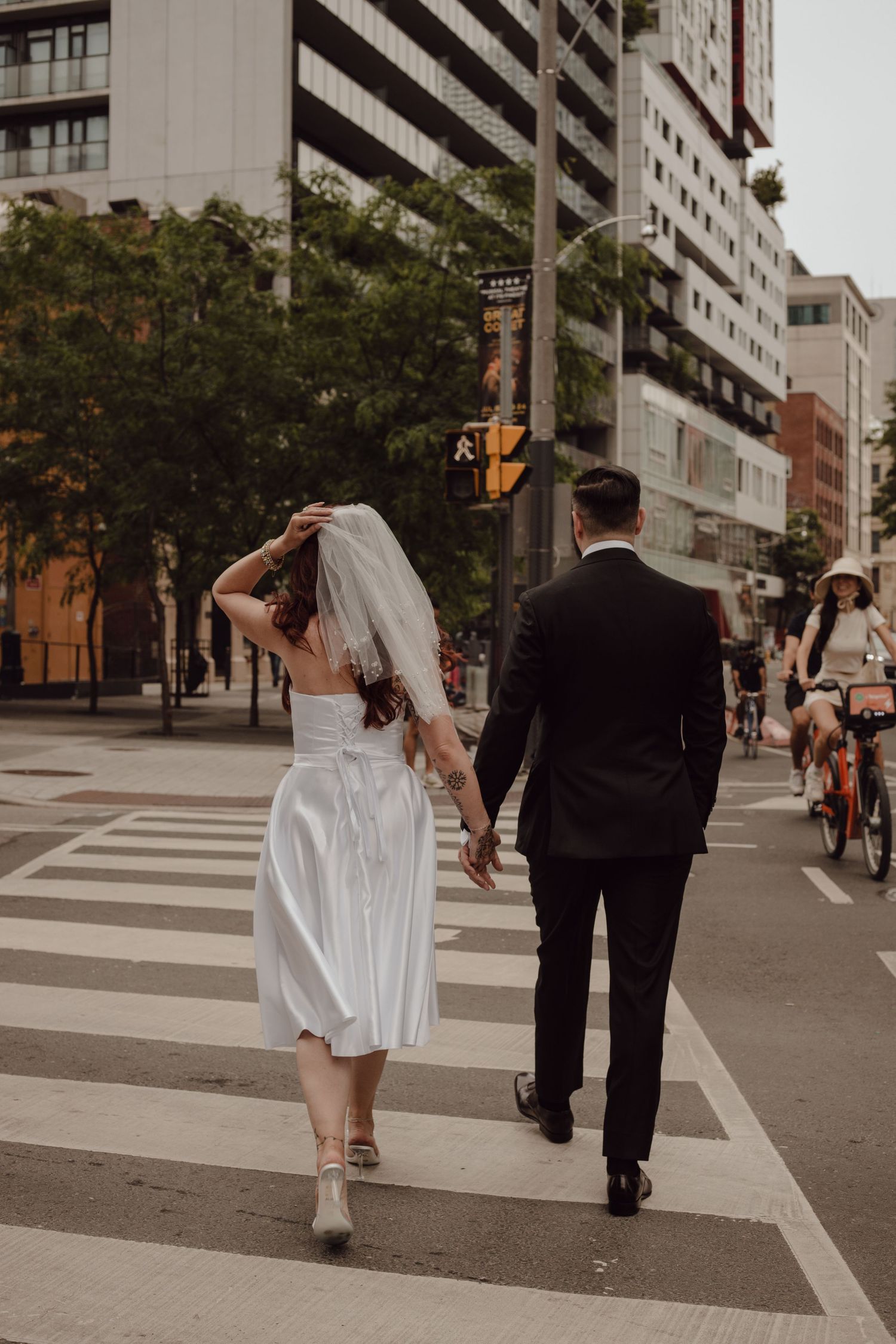 Candid shot of bride and groom walking through Toronto on their way to city hall for their elopement.
