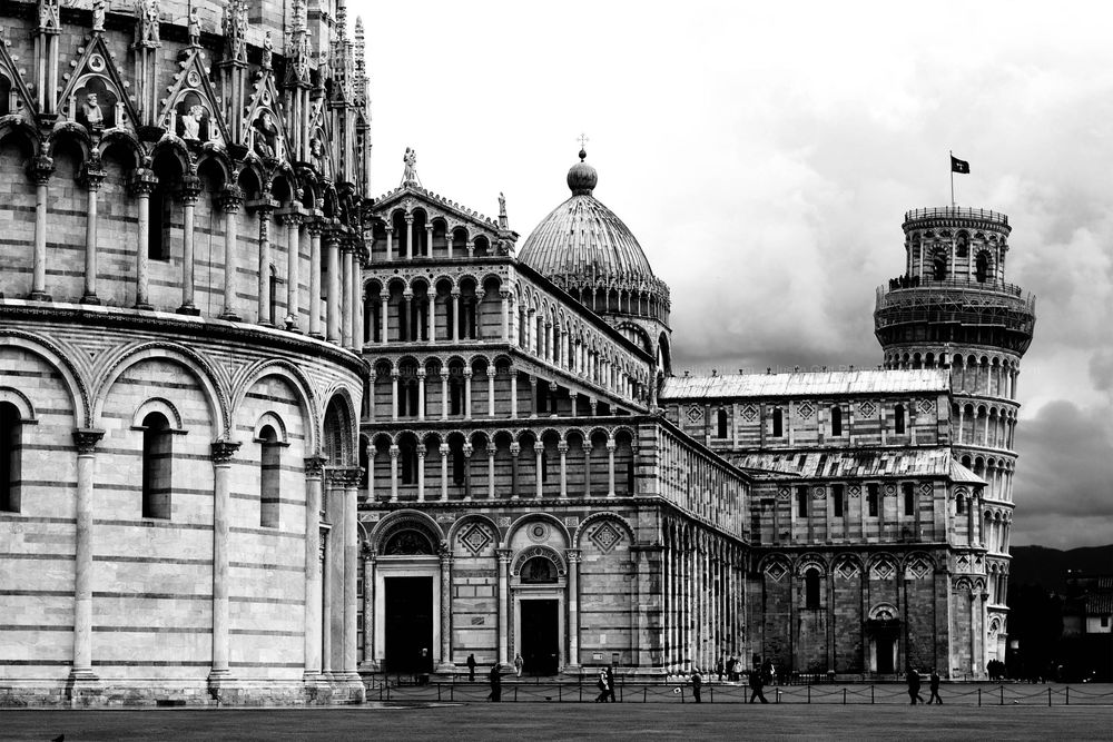 Black and white architectural photograph of the Pisa Cathedral complex with its famous leaning tower.