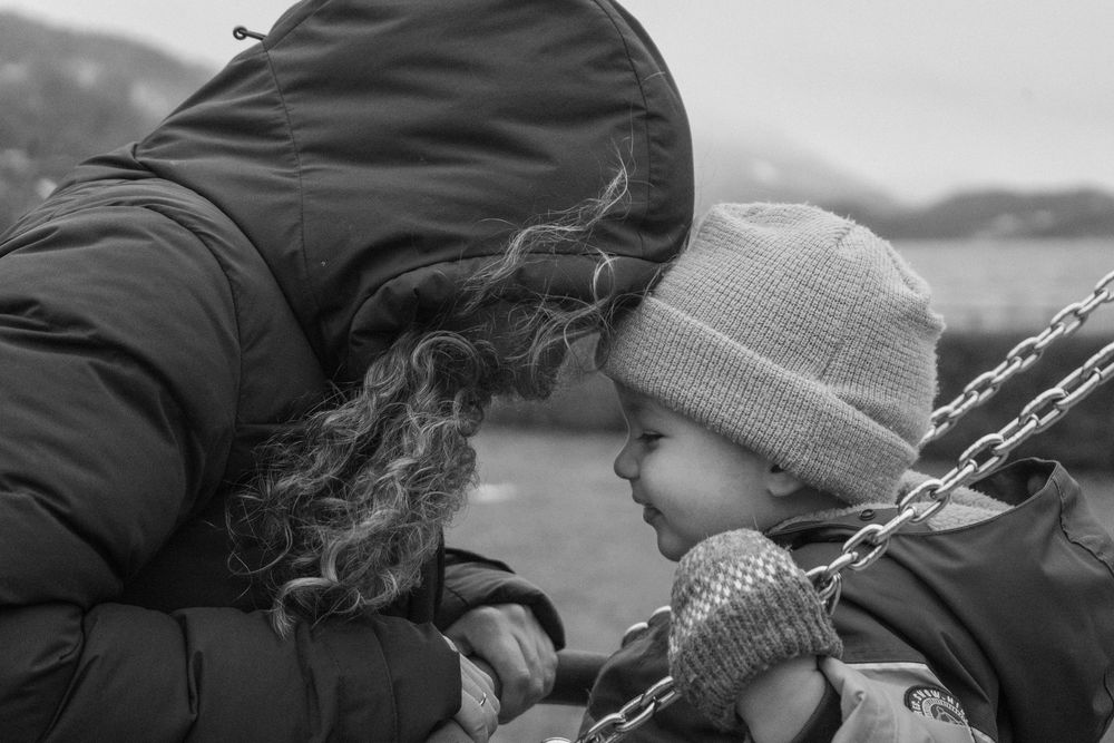 Two people sharing an intimate moment while sitting outdoors.