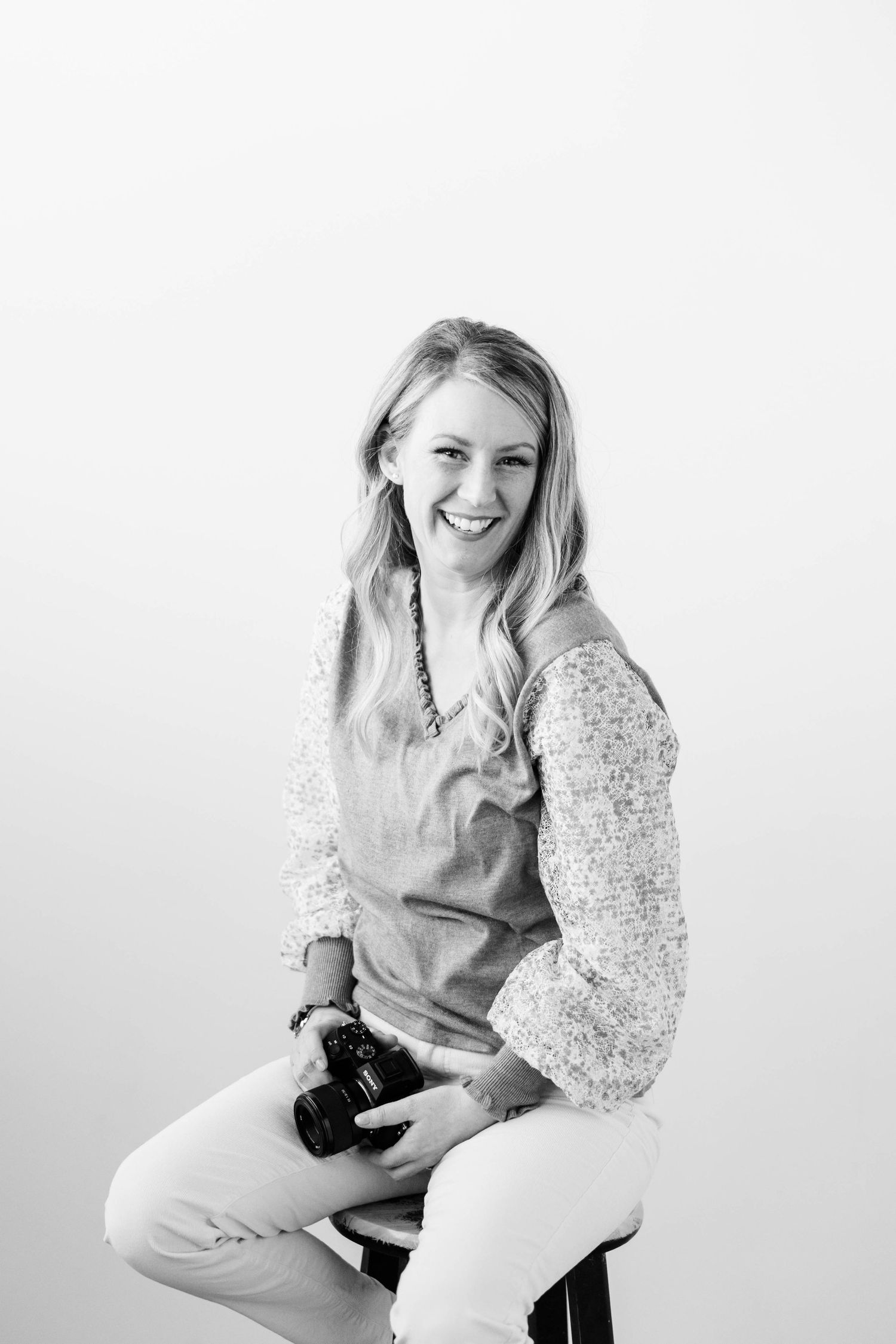 A series of black and white studio portraits showing a person in casual attire sitting and smiling against a white backdrop.