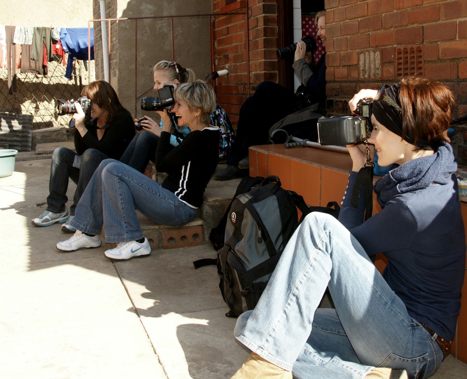 Jozi-Johannesburg photography. Students and instructor laughing , using their Canon, Nikon and camera external flashes. Street photography.