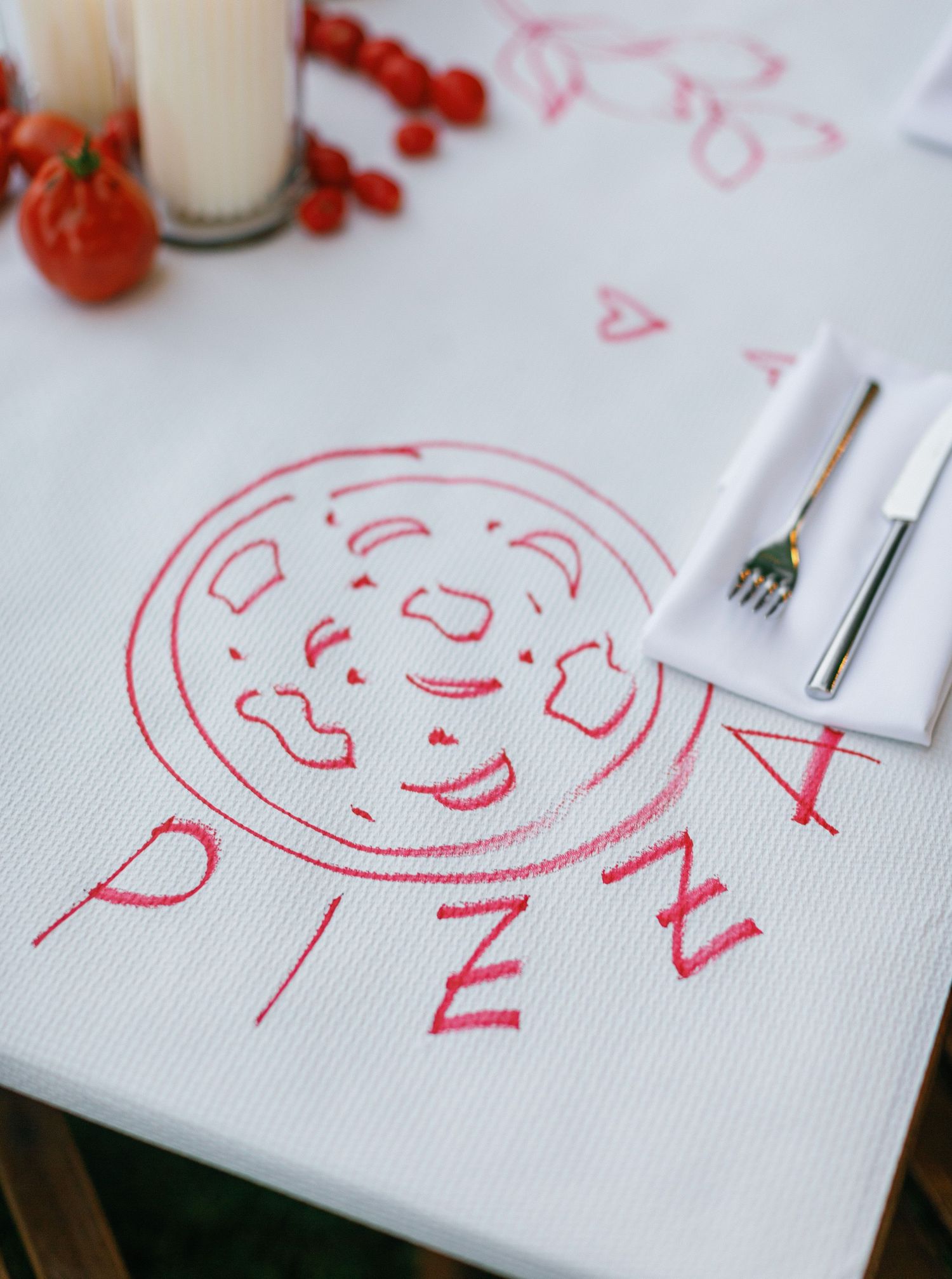 A red sketch drawing is being created on white paper with art supplies and decorative berries in the background.