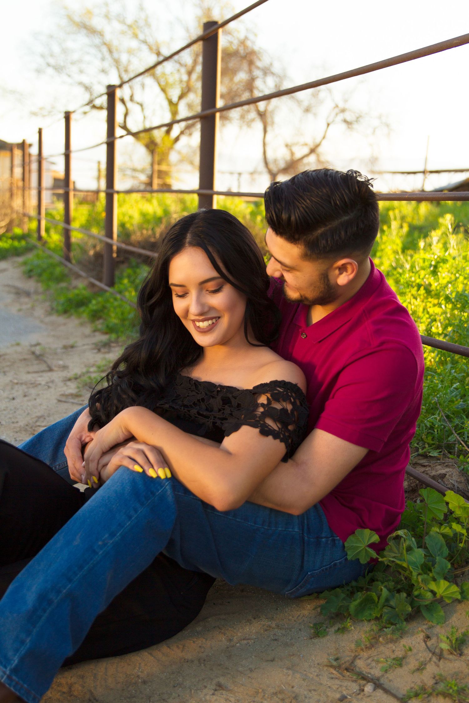 Couple sitting while embracing one another on their engagement session