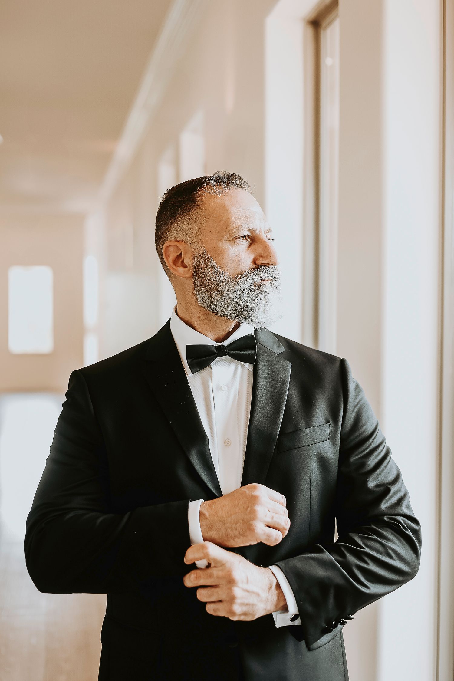 Groom adjusting his jacket before vineyard wedding ceremony