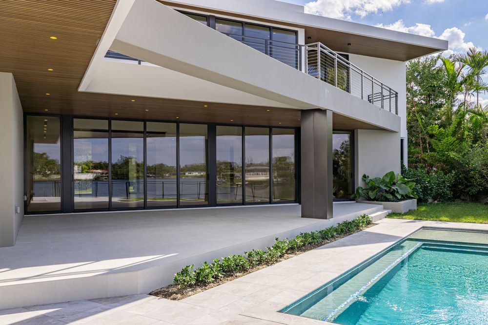 Expansive outdoor living space with sleek white architecture and a lap pool stretching along the property.