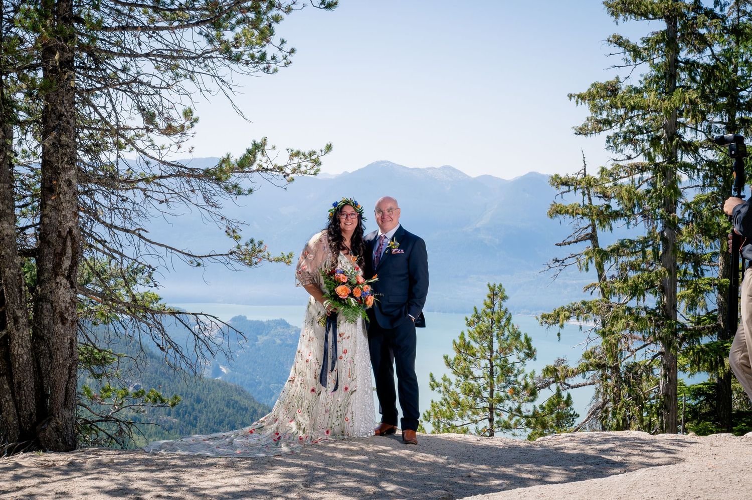 A couple stands together during their mountain wedding ceremony overlooking a scenic valley in Colorado.