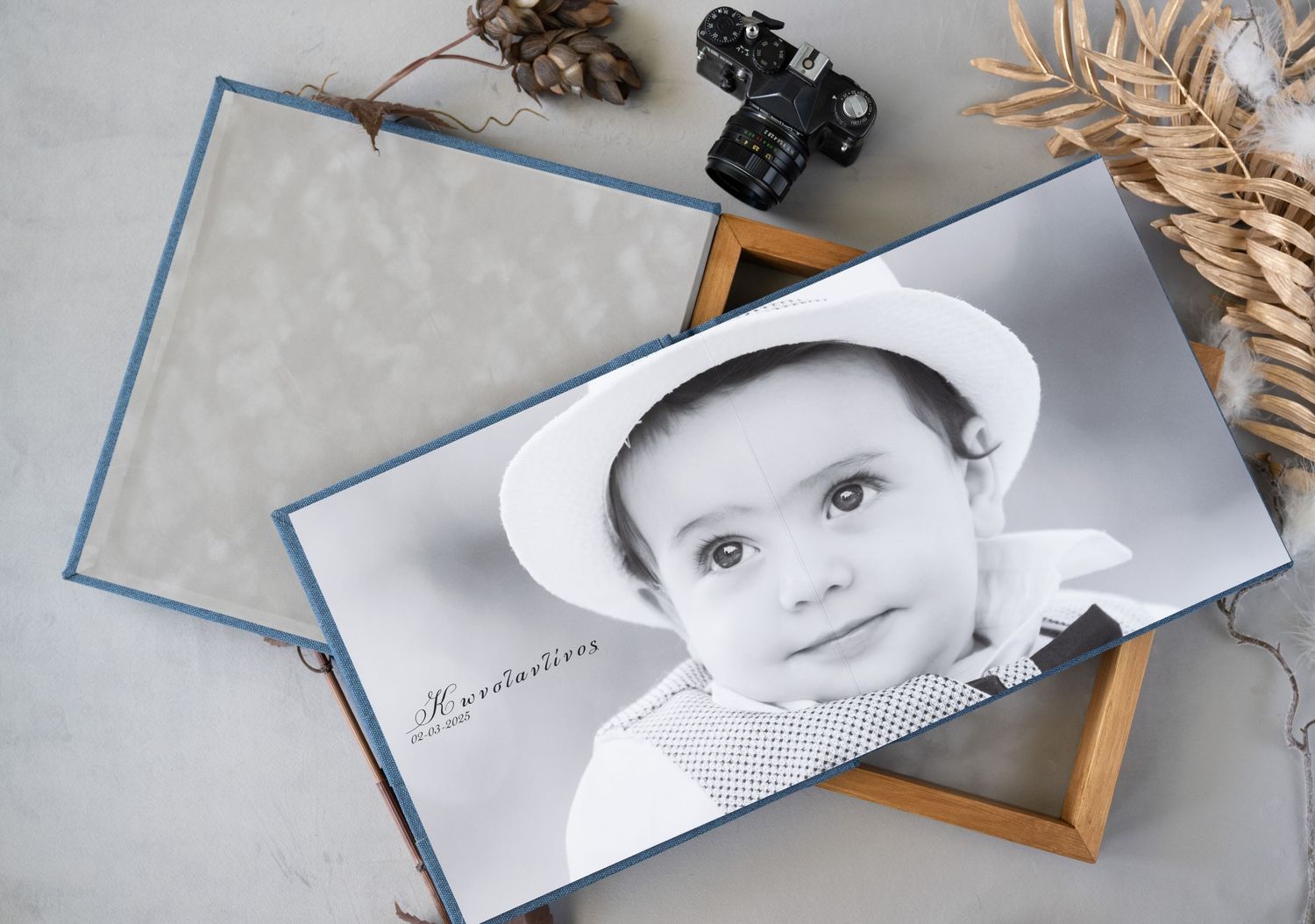 A black and white photograph displayed on a wooden frame with pinecones and dried leaves as decoration.