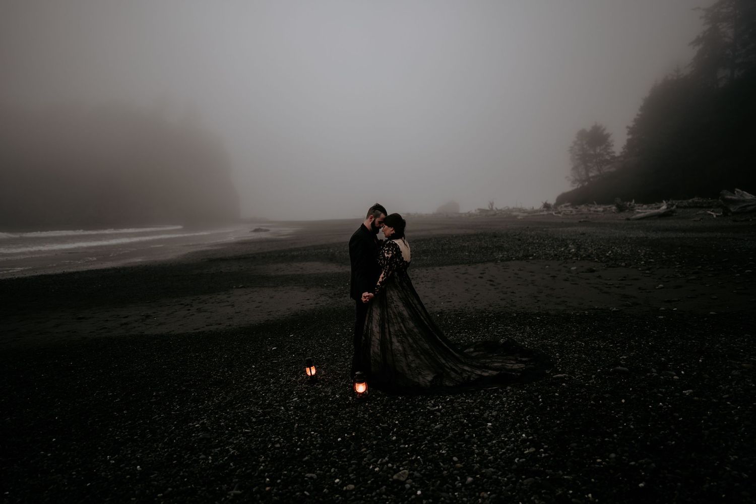 Husband and wife posing head to head in a black wedding dress for Ruby Beach Elopement at night.
