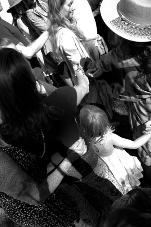 High-angle black and white view of people gathering at an outdoor event.