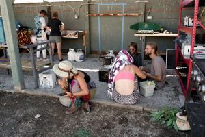 Workshop participants gathered in a rustic indoor space with shelving and supplies.