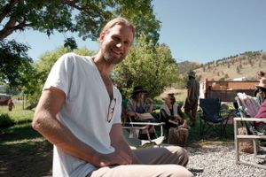 People enjoying a sunny outdoor gathering in a mountain setting.