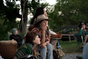 People gathered outdoors at sunset for a community farm event.