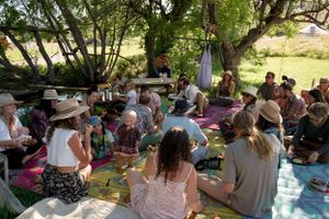 A casual outdoor meetup with attendees relaxing on picnic blankets.