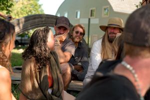 A group of friends sharing stories and laughter during an outdoor gathering.