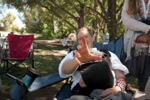Someone relaxing on a lounge chair at an outdoor festival.