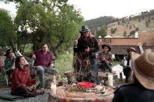 People gathered around a decorated fire pit area during an outdoor social event.