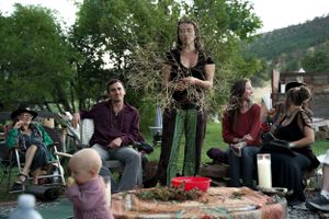 People gathered outdoors for a demonstration or presentation with trees in the background.