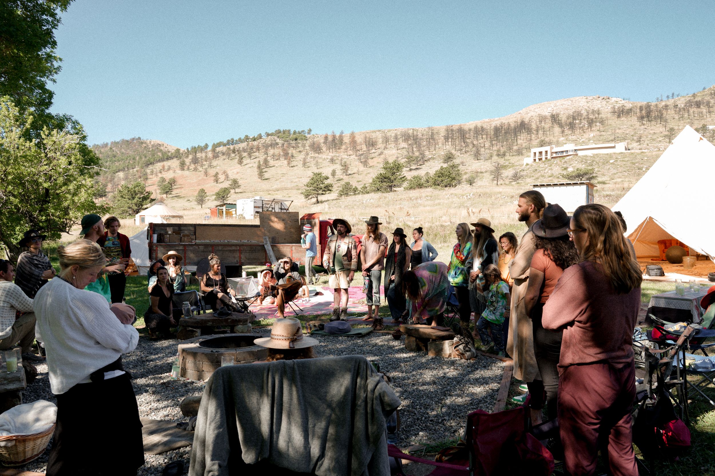 Guests mingle around buffet tables at an outdoor celebration with tents in the background.