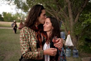 Couple sharing an intimate moment outdoors in casual bohemian attire.