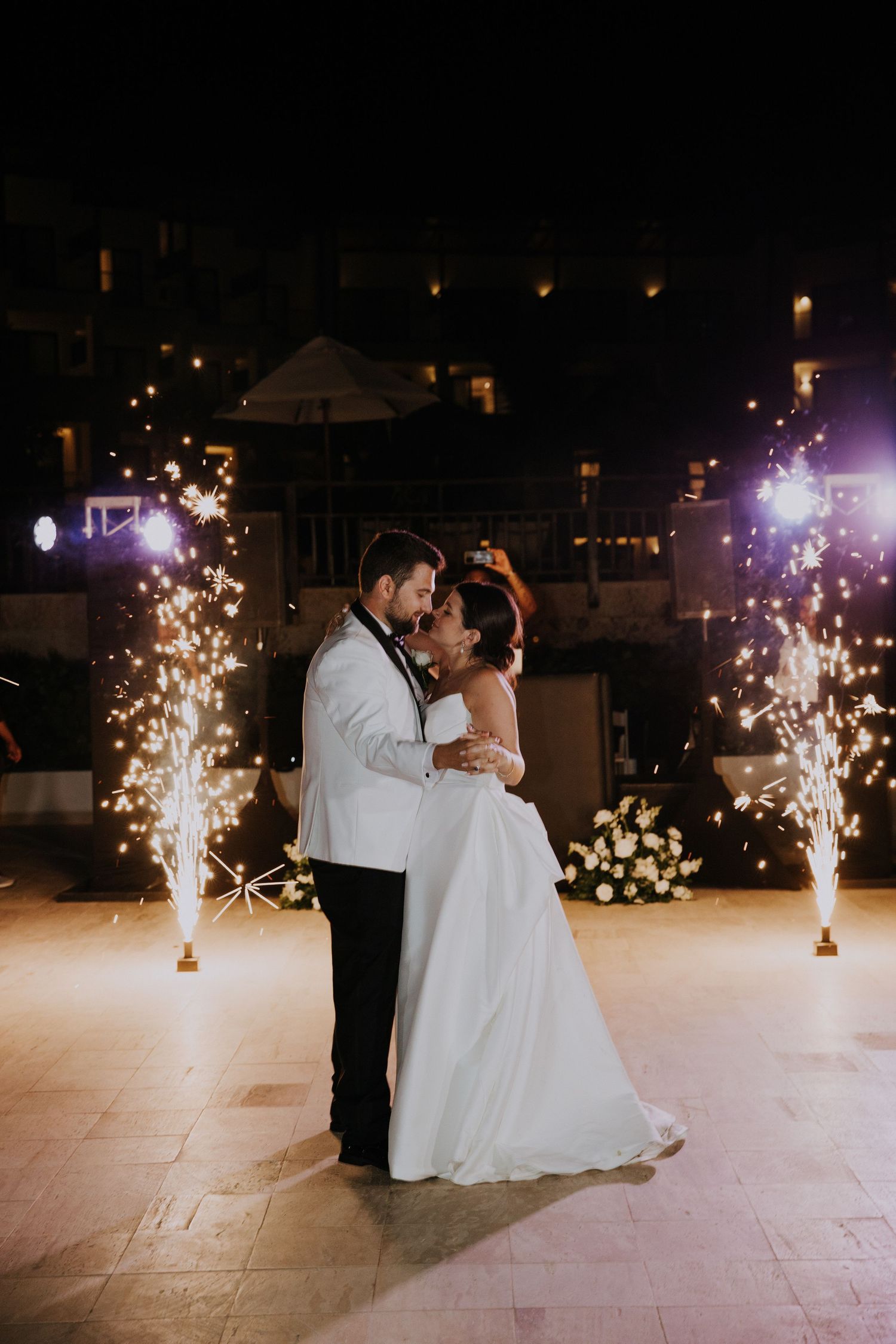 Couple shares romantic dance moment surrounded by golden sparkler fountains on dance floor at Dreams Macao