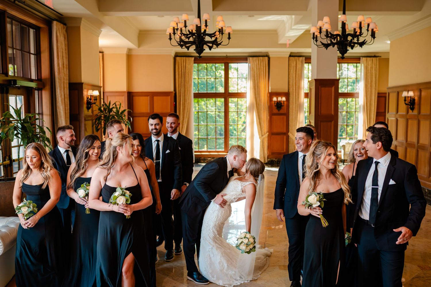 Wedding guests mingle and socialize in an elegant reception hall with warm lighting and beautiful decor.