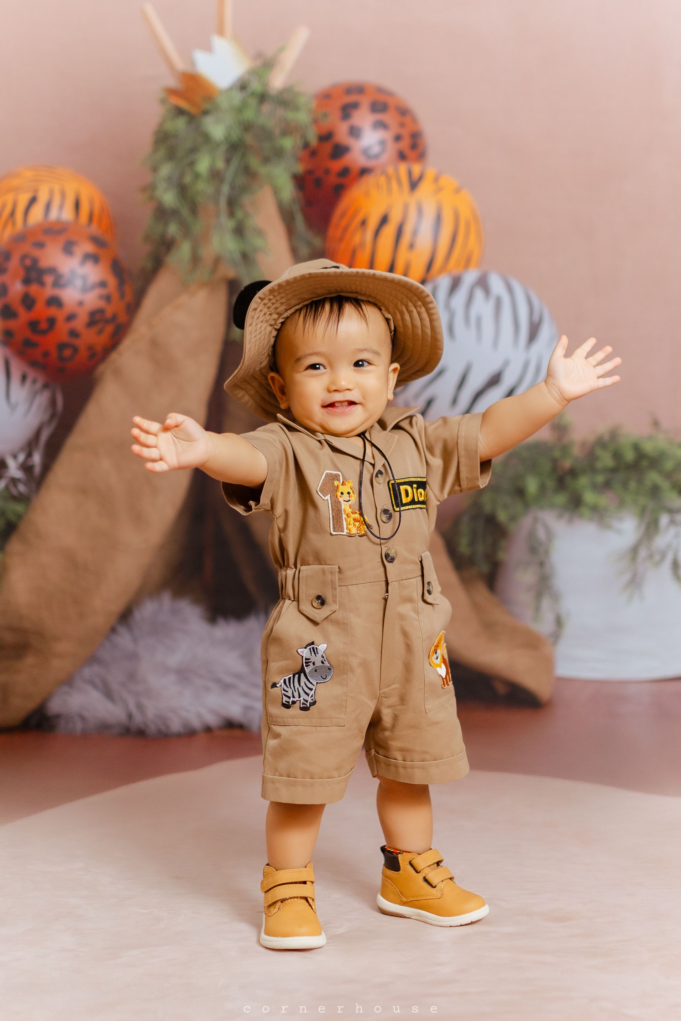 Safari-themed party setup with animal print balloons, greenery and decorations for a joyful celebration.