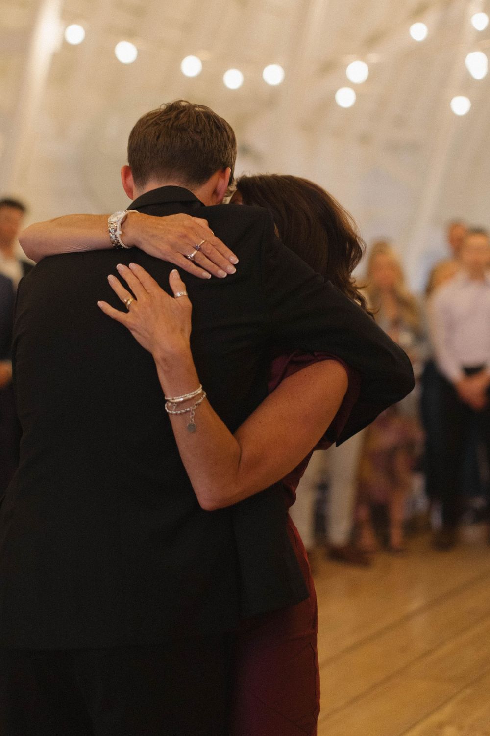 A tender moment between dancers is captured in warm lighting at a wedding reception.