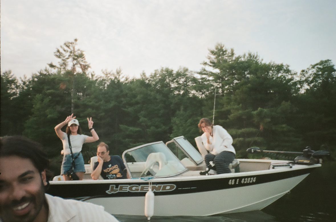 A group enjoys a sunny afternoon on a white Crestliner boat surrounded by trees on the water.