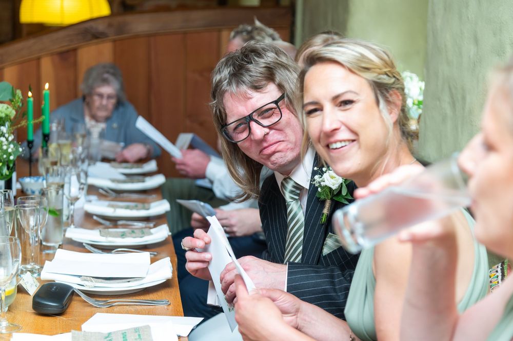 Wedding guests enjoying dinner and conversation at elegantly set tables.