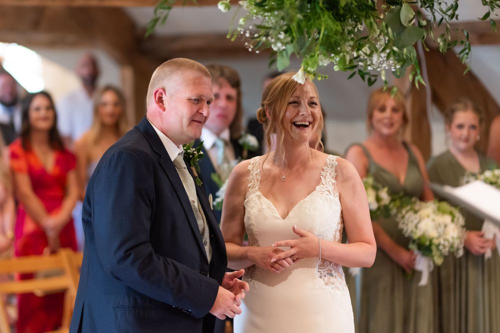 Wedding celebration with guests and couple laughing during reception.