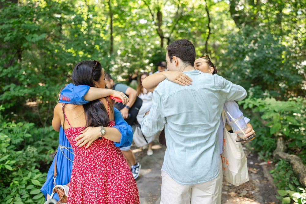 Friends congratulating a newly engaged couple after their proposal in Central Park at the San Remo lookout.