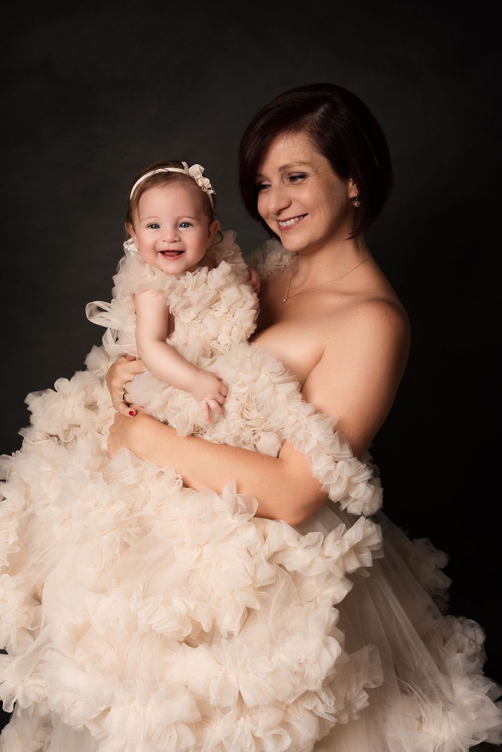 Dreamy portrait series featuring parent and baby in flowing ruffled dress.