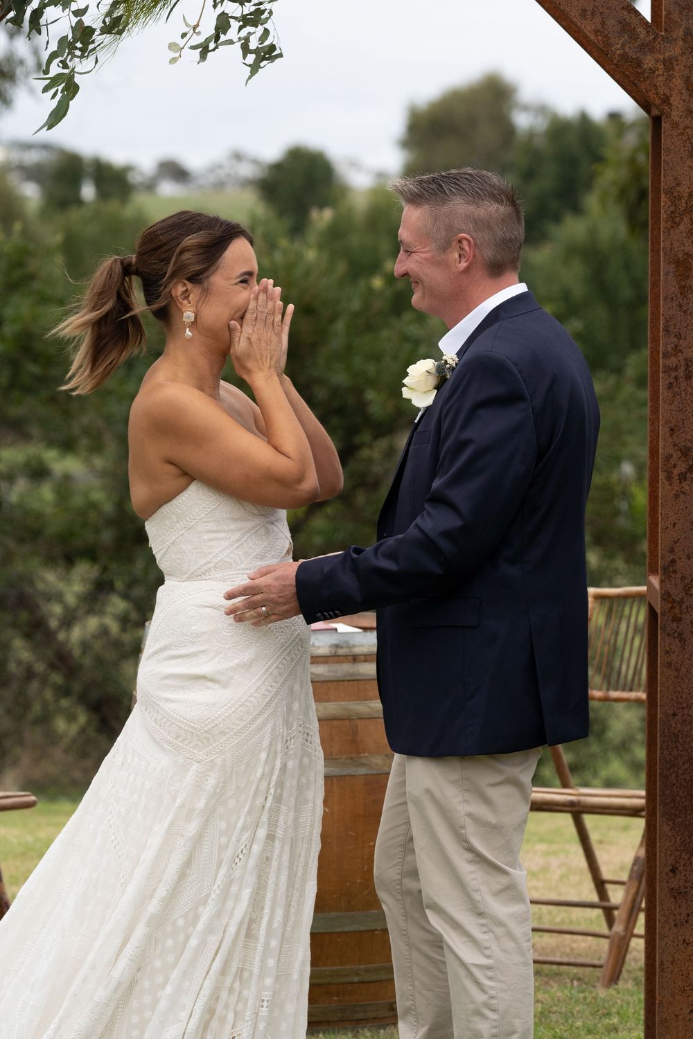 A heartwarming first look sequence between a bride in a white dress and groom in a navy suit on their wedding day.