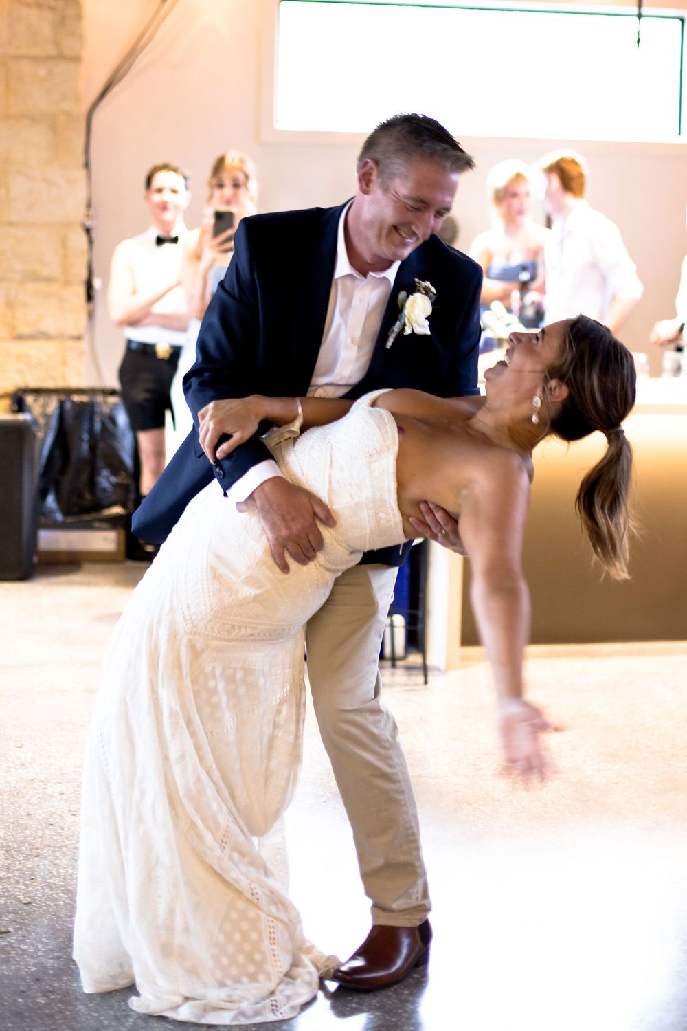 Romantic dance sequence showing a couple's graceful dip during their first dance at a rustic stone venue.