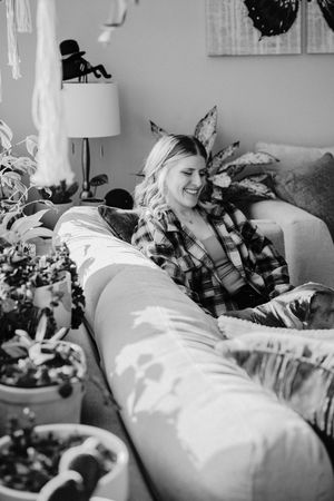 A relaxed moment on a cozy couch surrounded by indoor plants and home decor.  Indoor Lifestyle Session Denton Texas