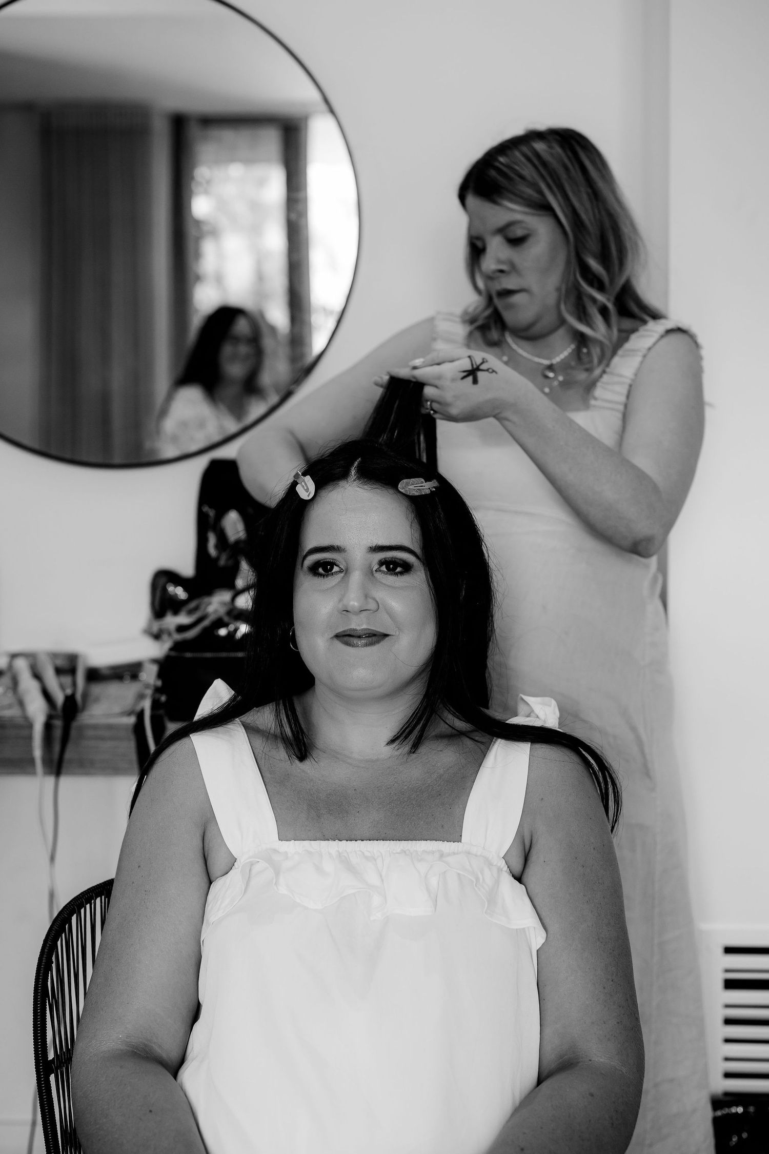 A wedding preparation scene shows white dresses and formal attire being fitted in a brightly lit room.