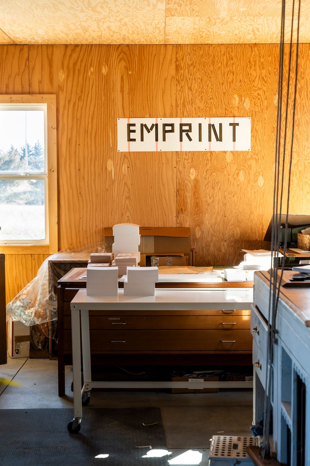 Letterpress printing workspace with EMPRINT sign and equipment.