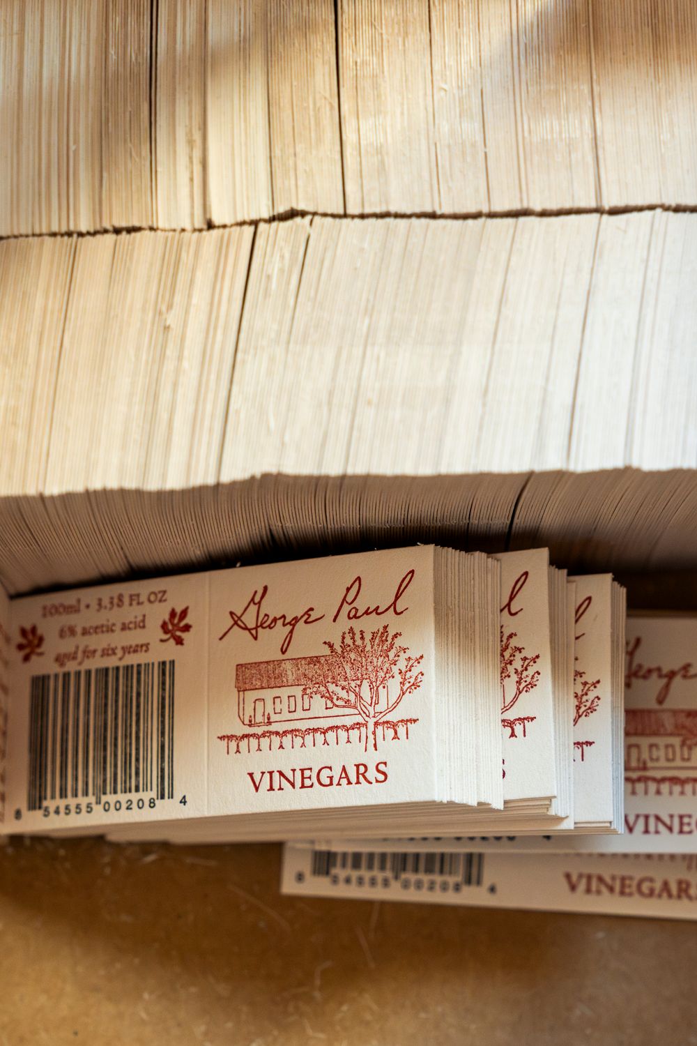 Stack of vinegar labels with barcodes on shelf.