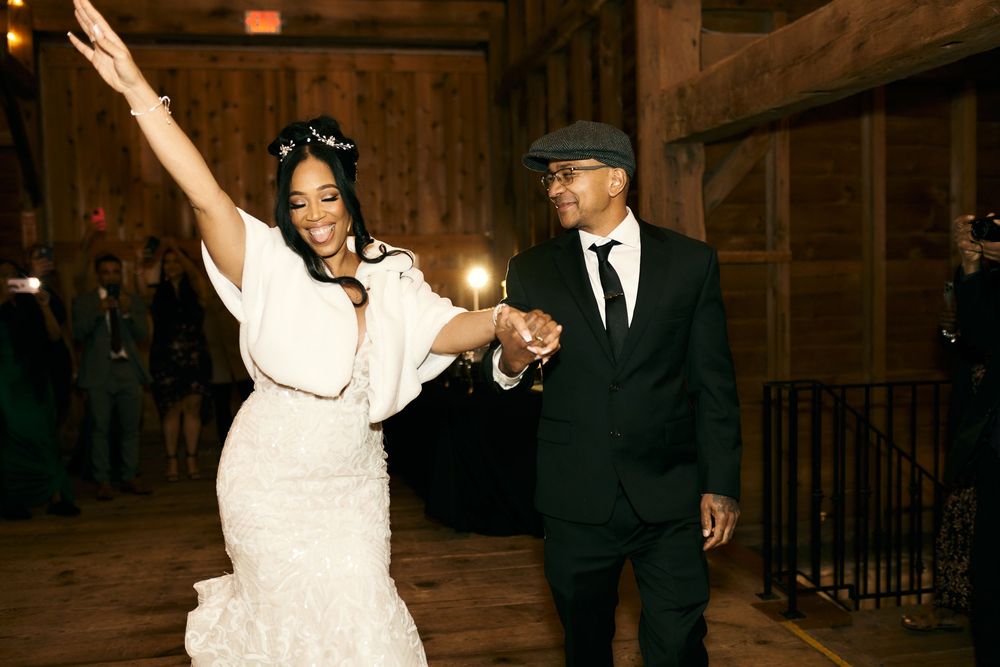A couple celebrates on their wedding night in a rustic venue with the bride in a white dress and groom in a suit.