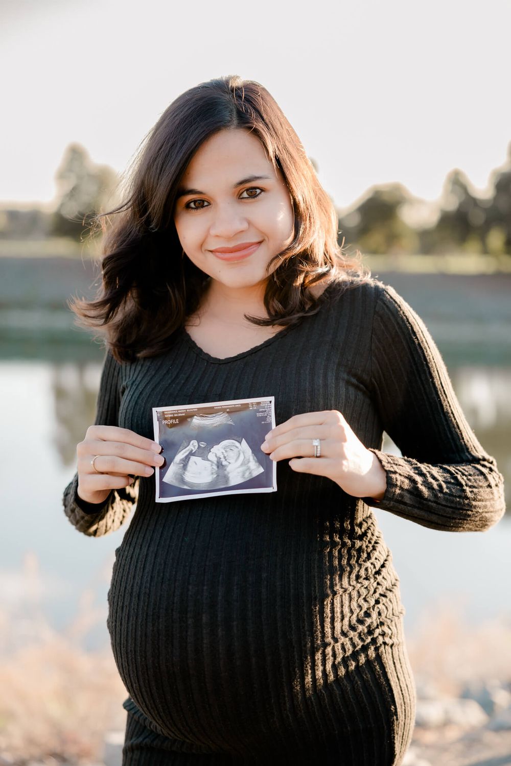 Pregnant mom smiling with family during golden hour maternity session in Fremont, CA