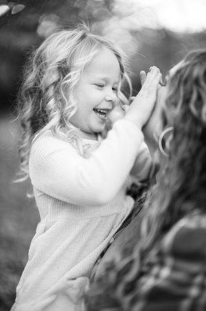 Black and white image of joyful play outdoors with a bright delighted expression.