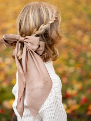 A sequence of close-up shots shows someone's hair blowing in the wind against a warm autumn background.