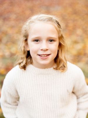 A series of five portrait photographs showing someone in a cream-colored sweater against a warm autumn background.