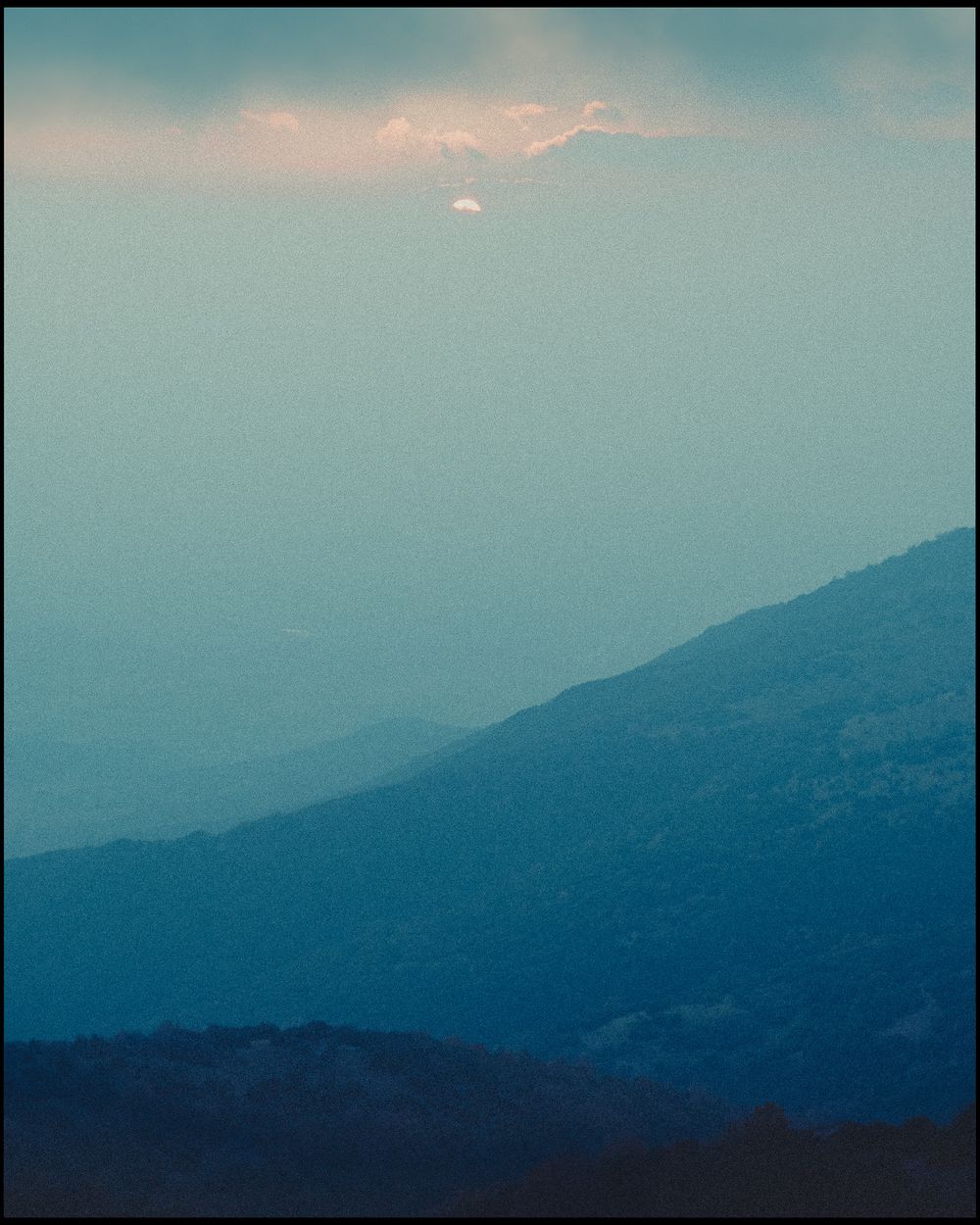 Blue-toned mountain layers fading into evening haze