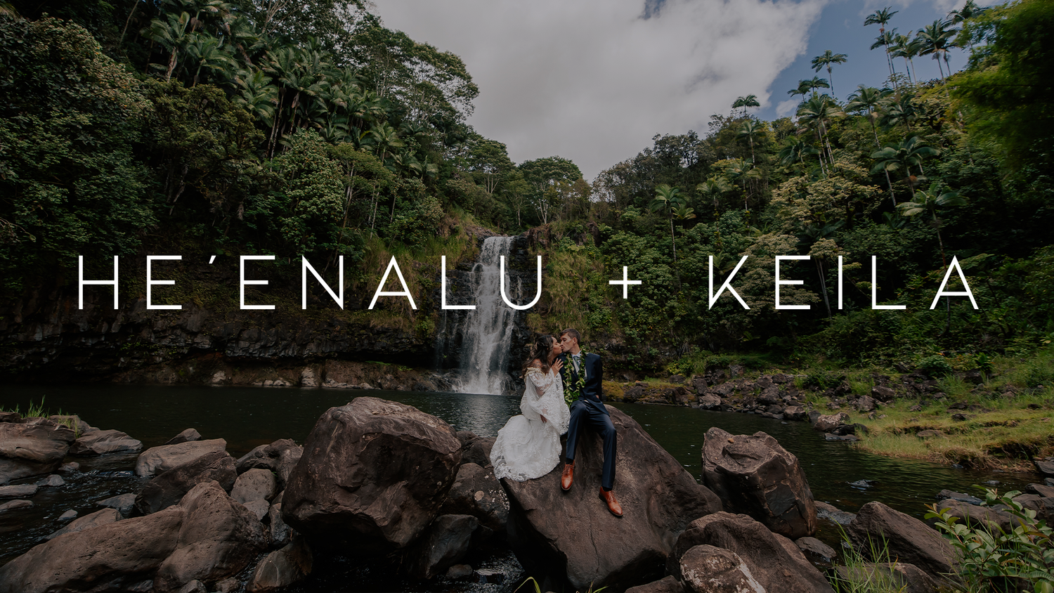 Wedding couple posing on rocky terrain with lush Hawaiian forest backdrop.