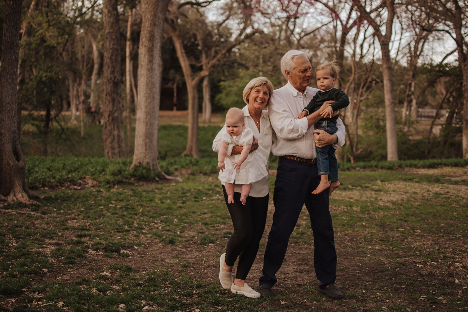 Family walking together through a wooded area in autumn while holding hands.